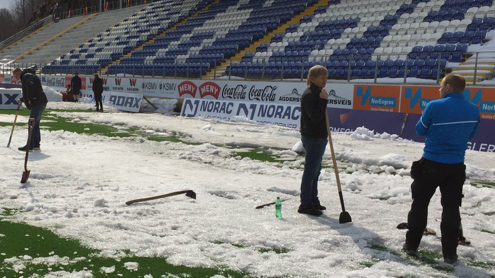 Preben Jørgensen har en pauseprat sammen med Arendal kommunes anleggsansvarlige Helge Hott Johansen lørdag ettermiddag. Først søndag var de ferdige med å fjerne all is og snø på banen.