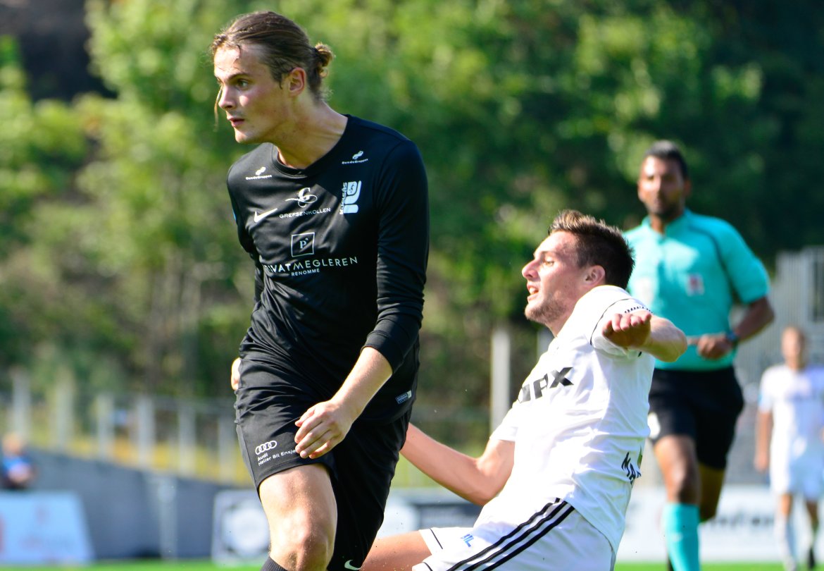 Adi Markovic prøver å nå ballen, men vi kan vel ikke se bort fra at dommeren kan ha valgt å blåse frispark mot ham akkurat her...
