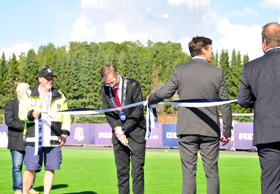 Anleggsansvarlig Per Carsten Michelsen og styreleder Jan Sigurd Otterlei holder snorer for ordfører Robert C. Nordli som markerte den høytidelige åpningen av Norac stadion.