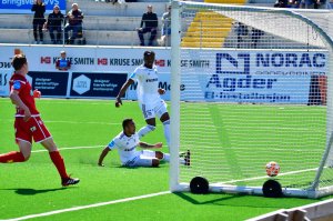 Ulrik Reinaldo Berglann kaster seg frem og gir Arendal 1-0. I bakgrunnen følger Vital Kaba med, mens Levanger-forsvaret kommer for sent.