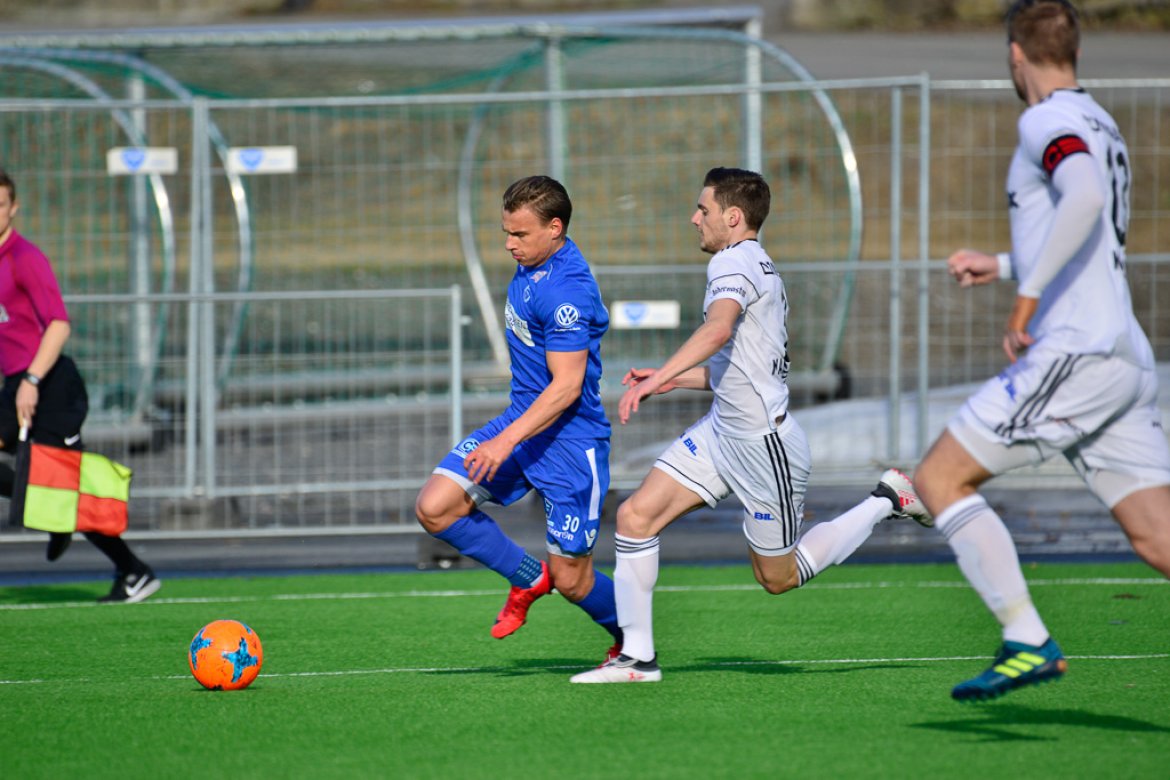 Lasse Sigurdsen og Adi Markovic i løpsduell. Sune Kiilerich (nærmest) gjør sikringsjobben.