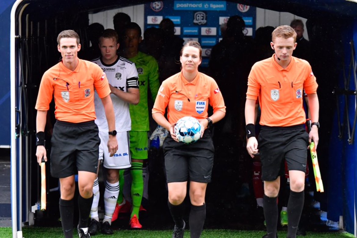 Emilie Rodahl Torkelsen leder lagene inn på Norac stadion flankert av sine assistentdommere Per Thomas Byrkjedal og Marius Benkestok Vesterhus Schulz.