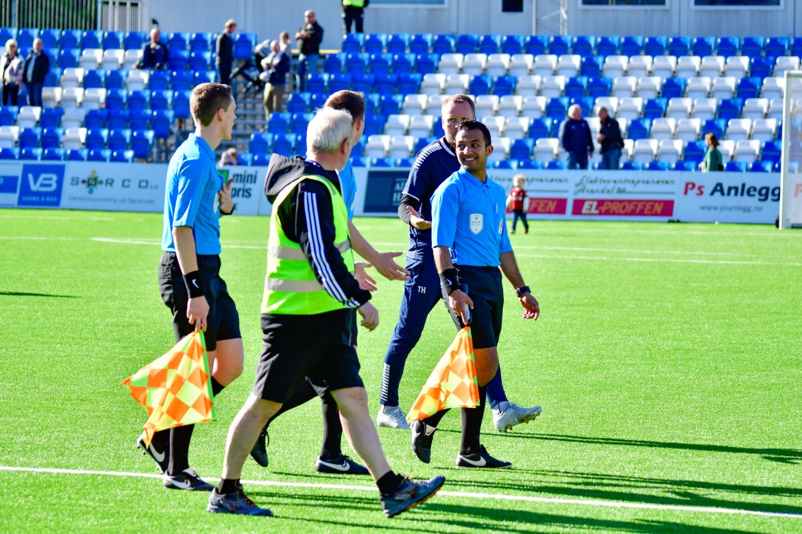 Per Carsten Michelsen i hyggelig passiar med dommertrioen etter at kampen er avblåst.